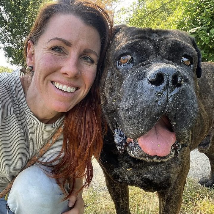 Linda wang aan wang met een grote gestroomde hond