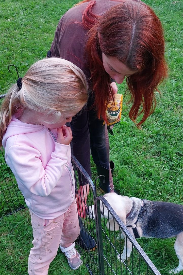 Linda met een kind en een hond, met een hekje ertussen